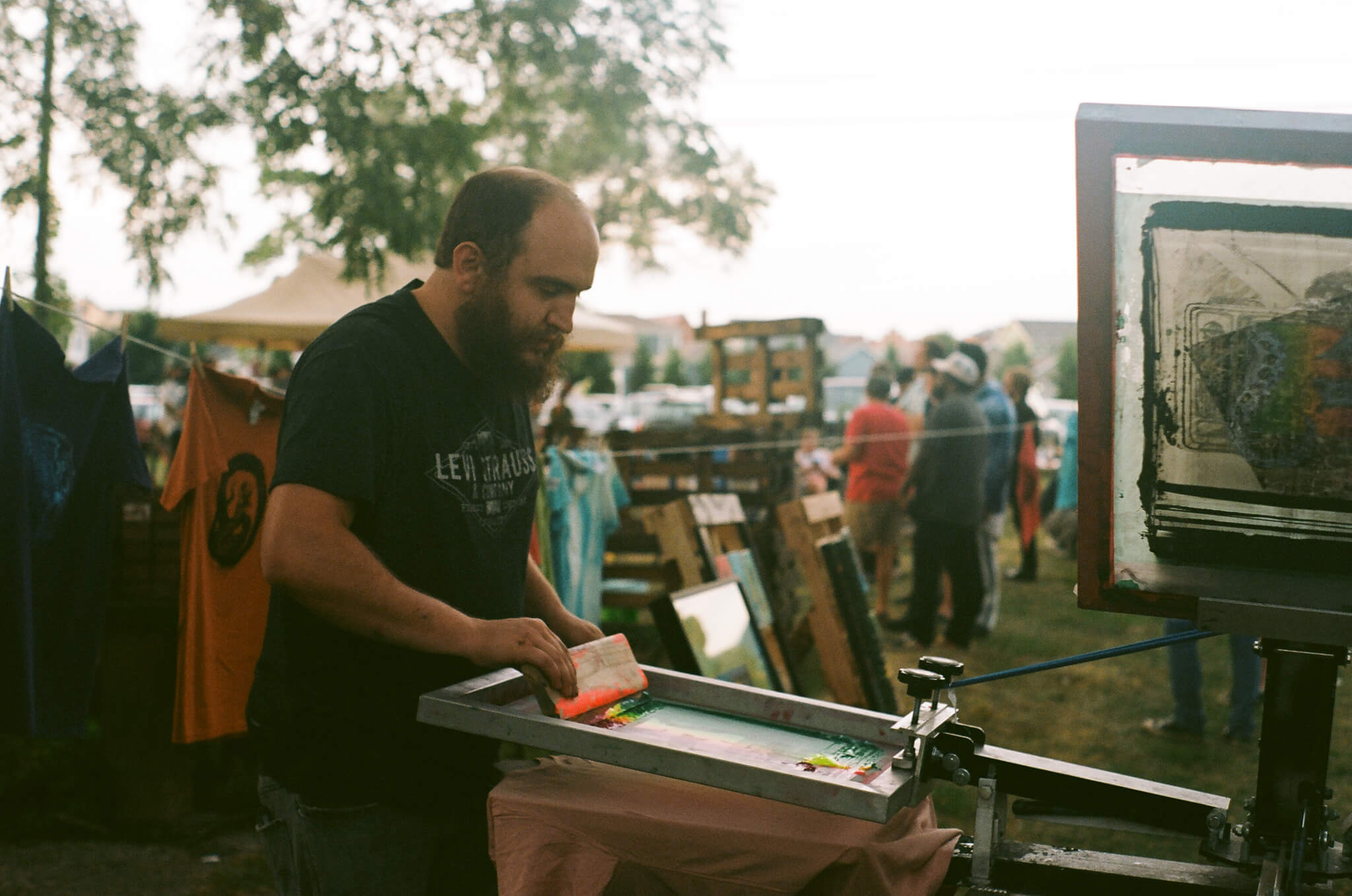 Bradley Davenport, artistic director of Mosaic Studios &amp; Gallery, screen prints custom (Y)ART? tees.