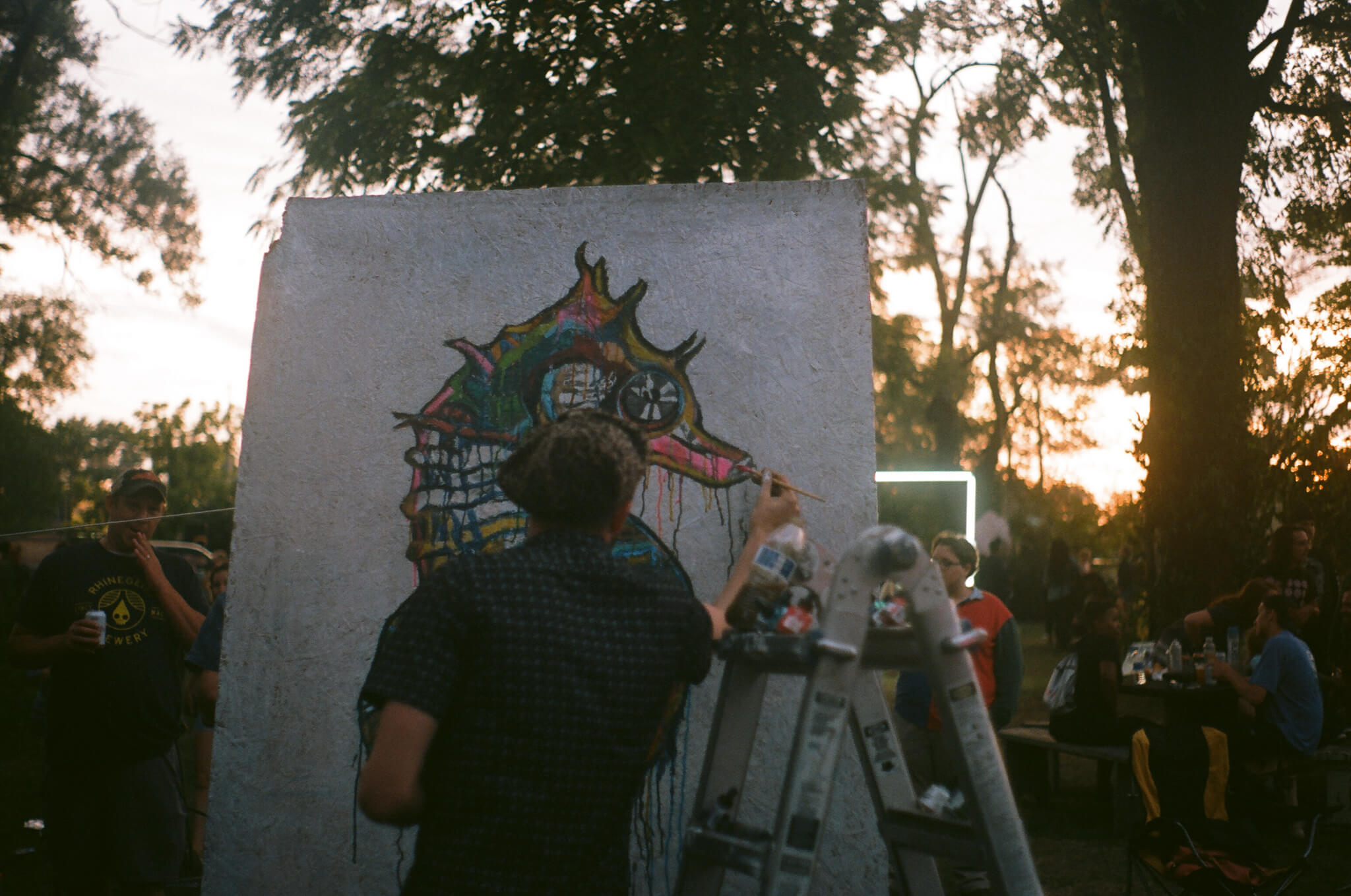 Russell Frantom works on a large-scale painting amidst the crowd.