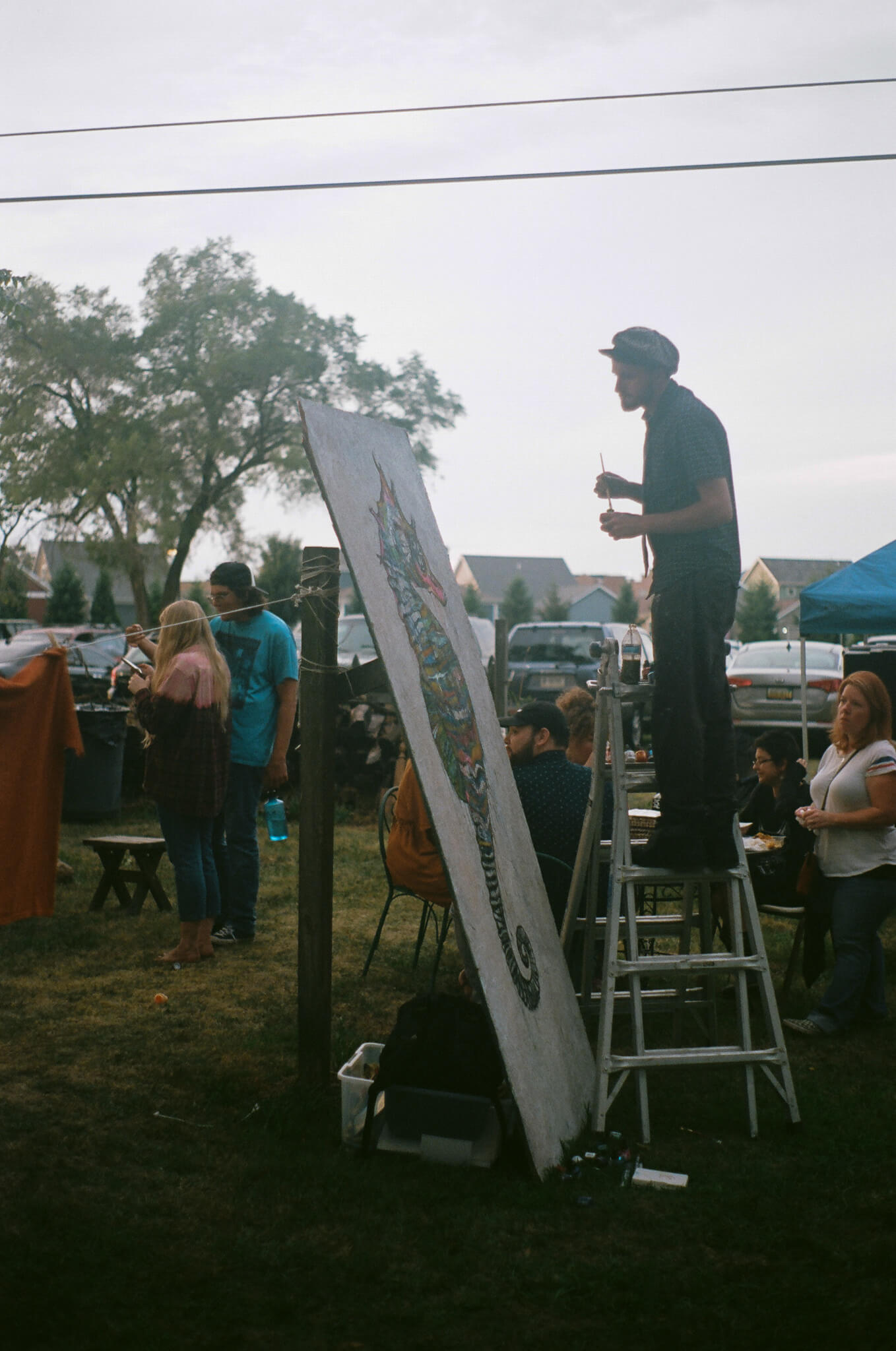 Russell Frantom works on a large-scale painting amidst the crowd.