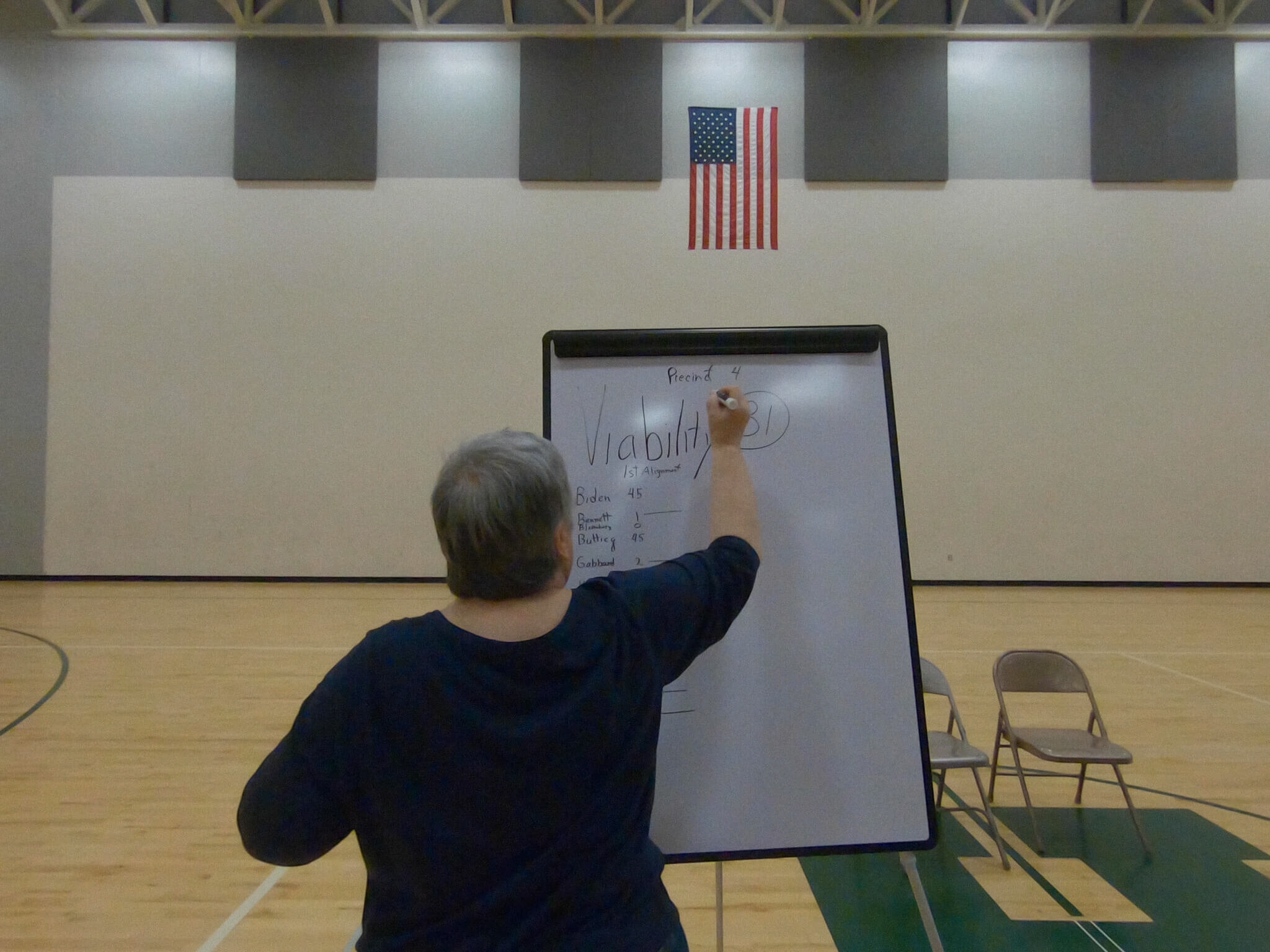 Sue, a Democratic Party volunteer, records first alignment numbers during the caucus.